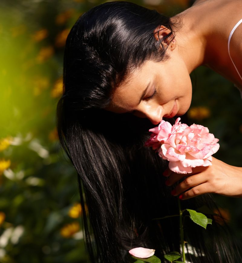 woman smelling flower and living in the moment