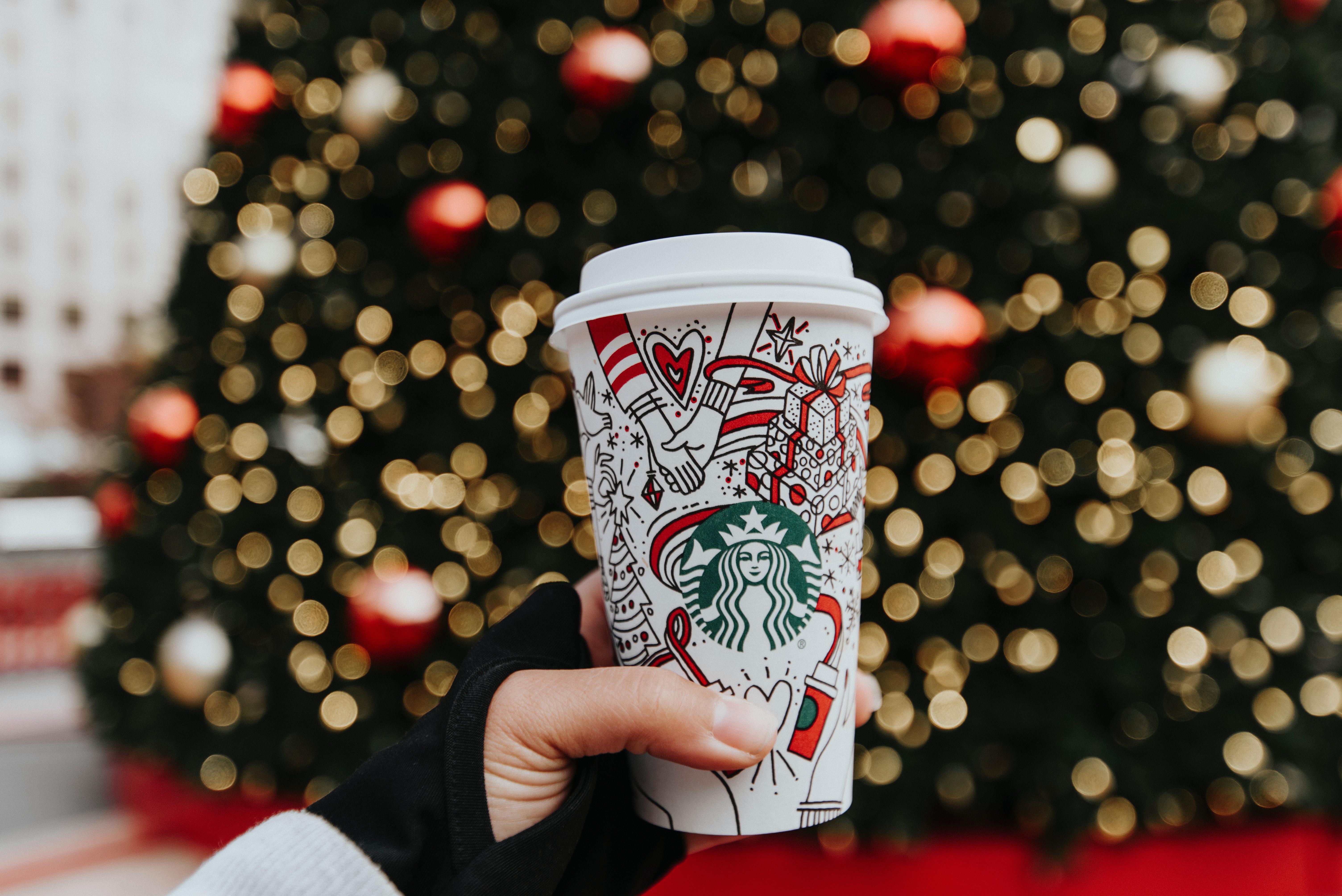 Self-care ideas holding Starbucks cup.