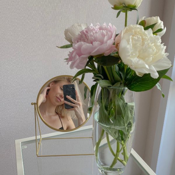 woman taking mirror self with flowers