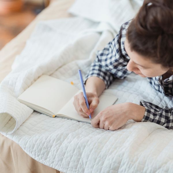 woman writing in journal and making a list