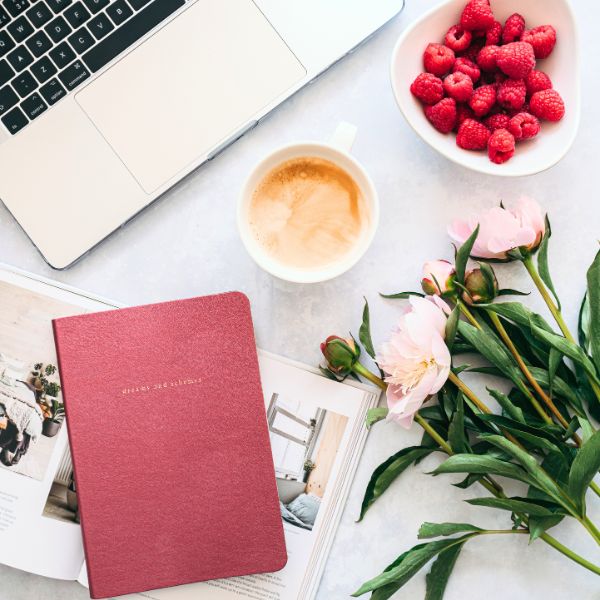 journal on desk with flowers